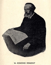 Photographie noir et blanc d'Edmond Edmont, portant une barbe et tenant un exemplaire de l'Abeille de la Ternoise.
