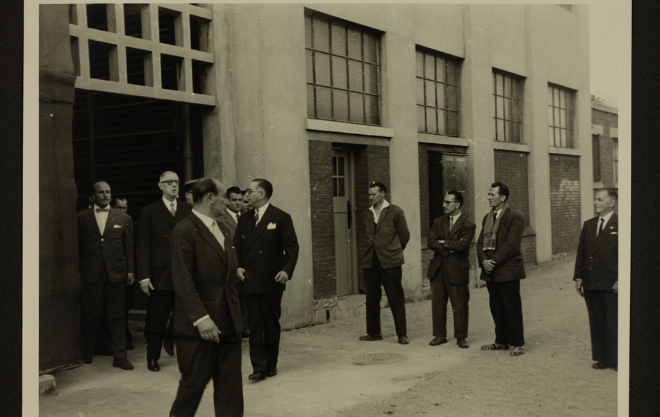 Le Général De Gaulle et les officiels sortent de l'intérieure d'un bâtiment de l'Usine des "Filés de Calais" lors de sa visite du 24 septembre 1959.